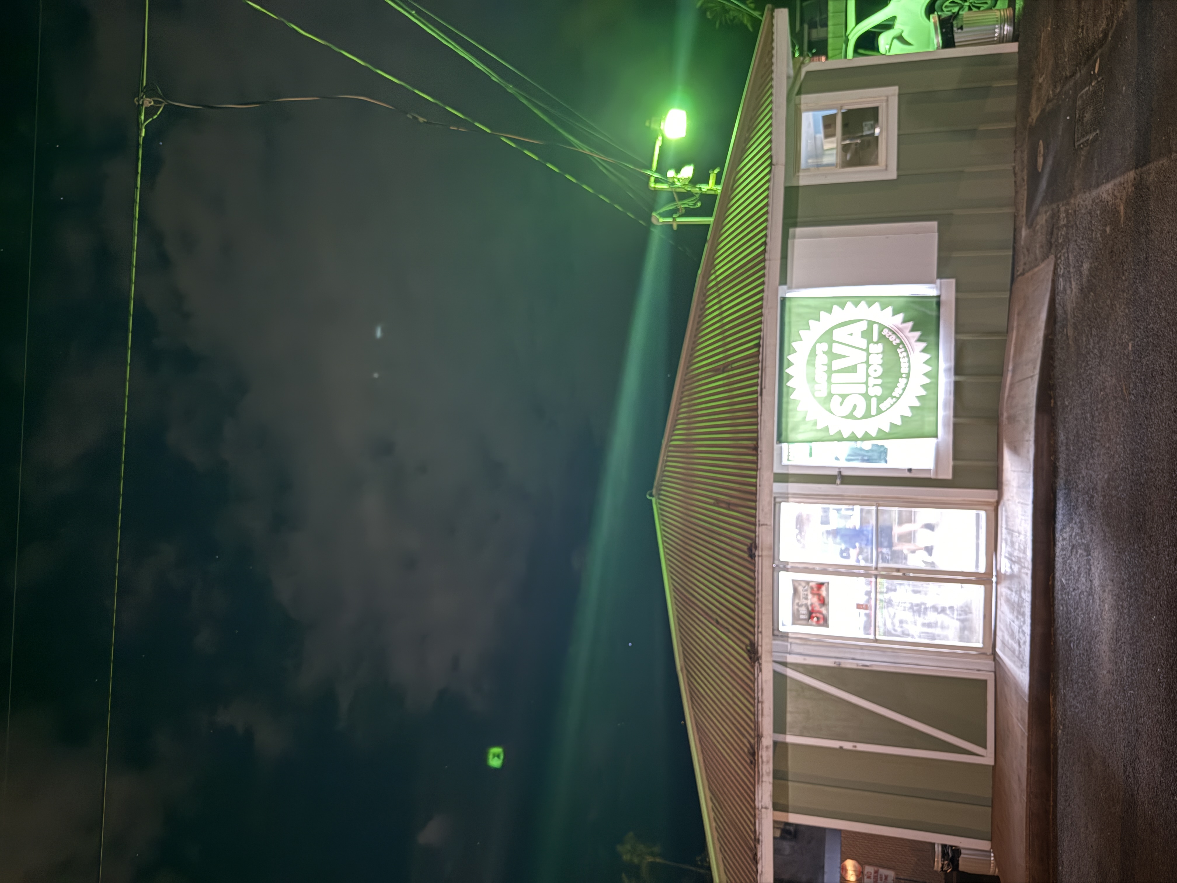 Lloyd's Silva Store exterior at night with green-lit sign